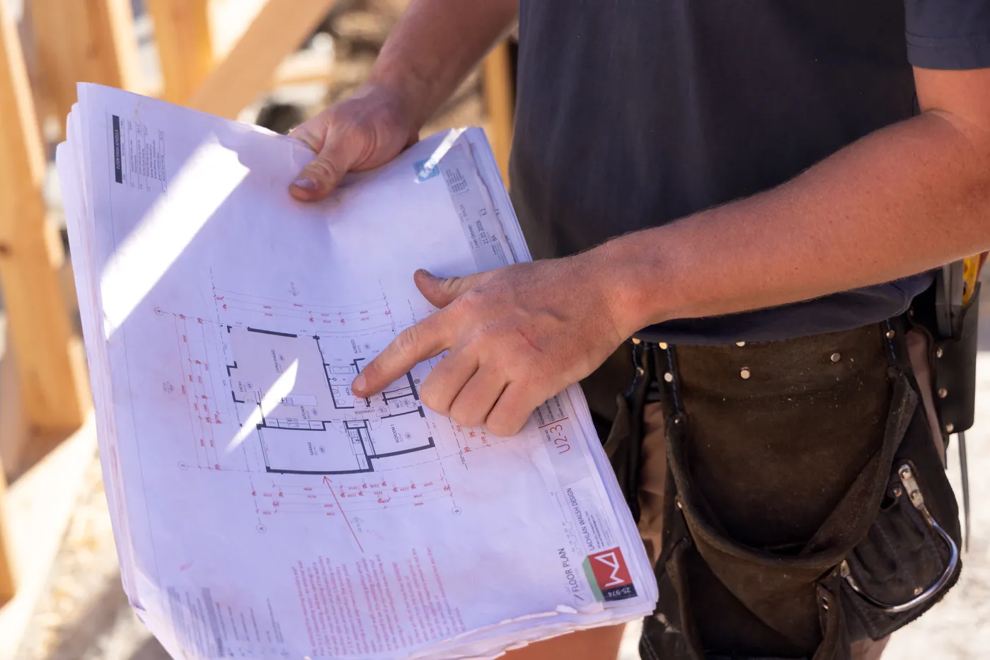 A TCB Build team member reviewing floor plans on site